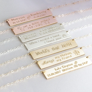 May include: A set of six gold, silver, and rose gold necklaces with personalized bar pendants. The pendants feature engraved messages such as "World's Best Mom", "It's not a home without fur-kids", and "When I needed a hand, I found your's".