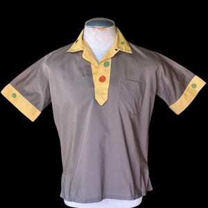 Camisa tipo jersey con cuello de lazo bordado en amarillo y gris, inusual, de finales de los 50/principios de los 60.