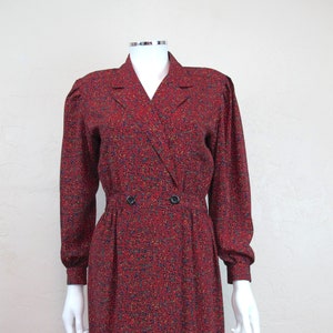 May include: A red, blue, and yellow patterned wrap dress with a double-breasted button closure.