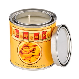 May include: A yellow and red can with the words "Corn Chips" and "Scented Candle" printed on it. The can has a picture of corn chips on the front. The can is open and the lid is off. The candle is white and is inside the can.