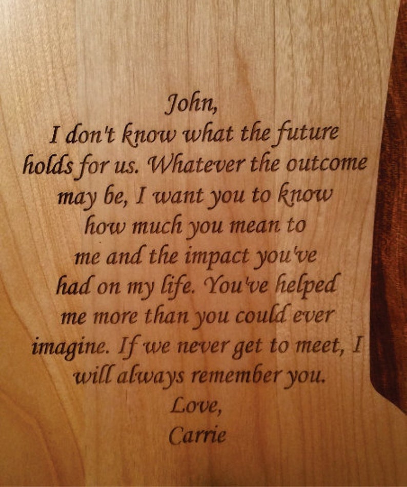 K&ouml;nnte beinhalten: Holztafel mit graviertem Text. Der Text lautet: &bdquo;John, ich wei&szlig; nicht, was die Zukunft f&uuml;r uns bereith&auml;lt... Love, Carrie.&ldquo;
