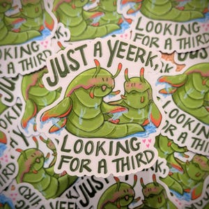 Puede incluir: Una colección de pegatinas con criaturas verdes de dibujos animados con detalles en rojo y naranja. Las pegatinas tienen el texto "JUST A YEERK, LOOKING FOR A THIRD" en una fuente lúdica. Las pegatinas son blancas con un borde troquelado.