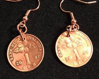 May include: A pair of copper earrings featuring a Malaysian 1 sen coin with the text "BANK NEGARA MALAYSIA 20 SEN 07" on each earring.
