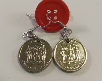 May include: A pair of earrings made from silver-colored metal with a red button at the top. Each earring features a silver-colored Jamaican one dollar coin with the words "Jamaica" and "One Dollar" printed on it.