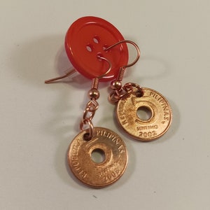 May include: A pair of earrings made with a red button and a Philippine 5 Sentimo coin from 2002.