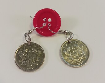 May include: A pair of earrings made with a bright pink button and two silver Ghanaian coins. The coins feature the Ghanaian coat of arms and the year 2007.