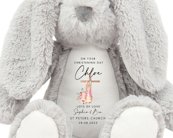 May include: A plush gray bunny rabbit with long floppy ears. The bunny has a white belly with text that reads "ON YOUR CHRISTENING DAY Chloe LOTS OF LOVE Sophia & Ben ST PETERS CHURCH 28.08.2023". A cross and floral design is also on the belly.