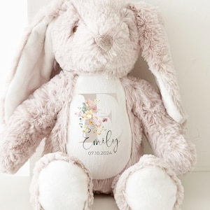 May include: A plush beige bunny with long ears, a white patch on its chest, and a personalised embroidered patch with the letter E, floral design, the name "Emily", and the date "07.10.2024".