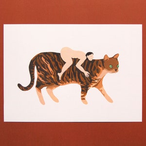 May include: A nude person riding a brown and black tabby cat with green eyes. The cat is walking forward with its head turned to the side.