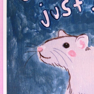 May include: A watercolor painting of a pink rat with a blue background. The rat is looking to the right and has a pink nose and pink ears. The text "Just Rat" is written in pink letters on the top of the image.