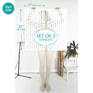 May include: A set of two stencils featuring a repeating pattern of small circles in shades of brown and gray. The stencils are 32 inches tall and 17 inches wide. The stencils are held by a person in front of a white wall. The text "SET OF 2 STENCILS" is printed on the stencils.