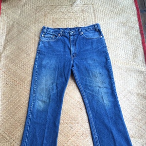 May include: A pair of blue denim jeans with a straight leg and a slight flare at the bottom.