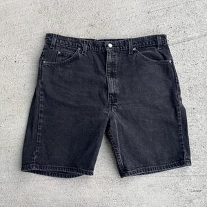 May include: Black denim shorts with a button fly and five pockets.