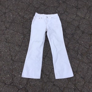 May include: White wide-leg jeans with a high waist and a slightly flared leg opening.