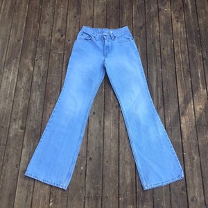Puede incluir: Un par de pantalones de mezclilla azul claro acampanados.