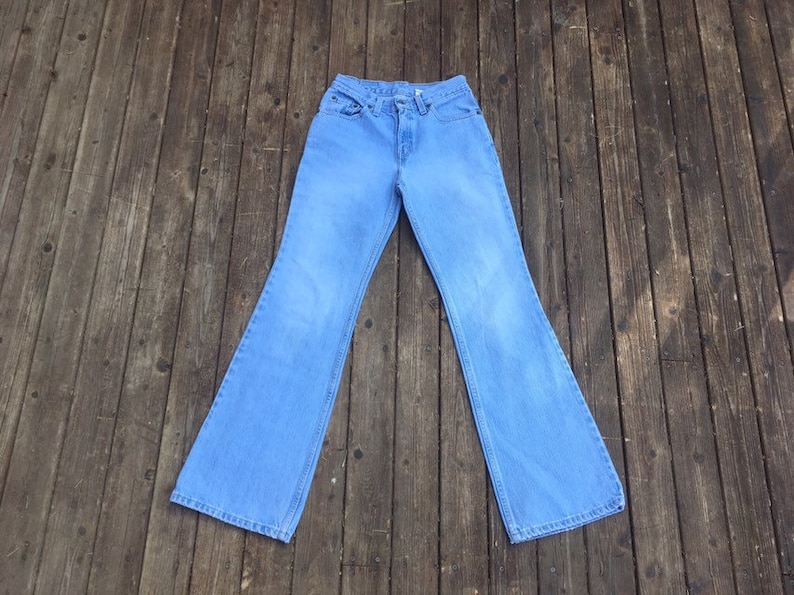 Puede incluir: Un par de pantalones de mezclilla azul claro acampanados.