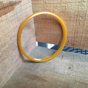 Puede incluir: Un brazalete de plástico amarillo.