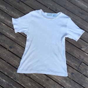 May include: A white ribbed short-sleeved t-shirt with a small tag that says "EIGHTY EIGHT" on the neckline.