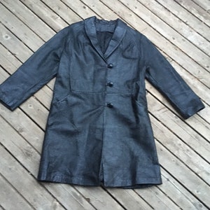 May include: A long black leather coat with a collar and button closure.
