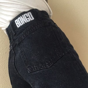 May include: Black denim jeans with a white "BONGO" logo on the back waistband.