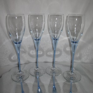 Puede incluir: Cuatro copas de champ&aacute;n transparentes con tallos y bases de color azul claro. Las copas tienen un dise&ntilde;o delgado y elegante, ideal para celebraciones. Los tallos son de un azul delicado, a&ntilde;adiendo un toque de color al cristal transparente.