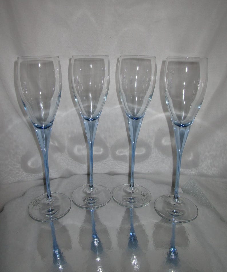 Puede incluir: Cuatro copas de champ&aacute;n transparentes con tallos y bases de color azul claro. Las copas tienen un dise&ntilde;o delgado y elegante, ideal para celebraciones. Los tallos son de un azul delicado, a&ntilde;adiendo un toque de color al cristal transparente.
