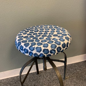 May include: A chair cushion with a blue and white patterned fabric cover and a metal base.