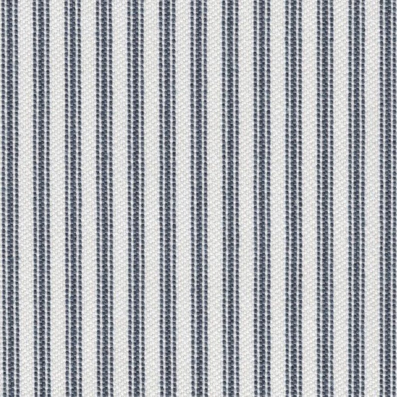 May include: A textile fabric featuring a repeating pattern of vertical stripes in dark navy blue and white. The design consists of thin, dark blue lines alternating with wider white bands, creating a consistent, linear, and textured appearance.