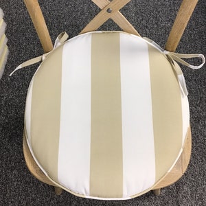 May include: A round beige and white striped chair cushion with ties.