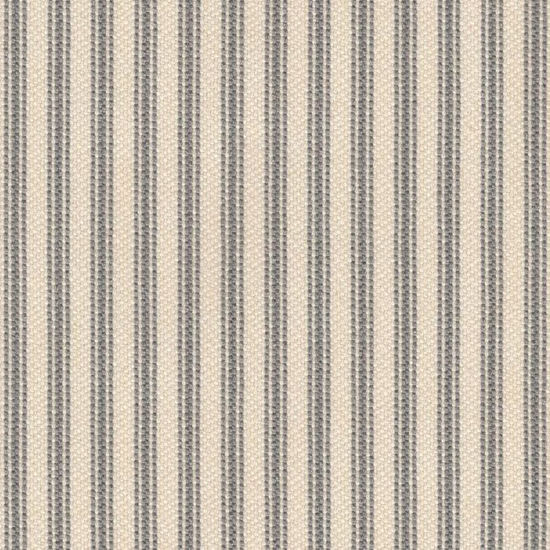 May include: A woven fabric featuring a repeating pattern of vertical stripes in dark gray and off-white. The texture of the textile is visible, showing a consistent weave throughout the material with alternating thin and thick dark gray lines.