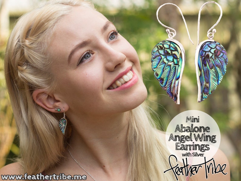 Puede incluir: Un par de pendientes de plata con alas de &aacute;ngel de concha de abul&oacute;n. Los pendientes son de color azul claro, verde y morado. El texto "Mini Abalone Angel Wing Earrings with Silver Feather Tribe" es visible en la imagen.