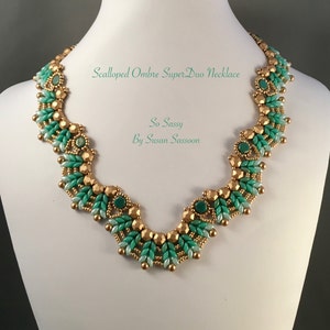 May include: Scalloped ombre SuperDuo necklace in gold and green tones. The necklace is called "So Sassy" by Susan Sassoon.