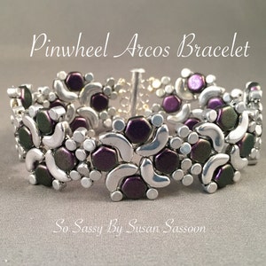 Könnte beinhalten: Ein silbernes und violettes Perlenarmband mit einem Windmühlenmuster. Das Armband heißt "Pinwheel Arcos Bracelet" und wird von "So-Sassy By Susan Sassoon" hergestellt.