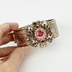 Coro Pegasus floral motif clamper bracelet, wide gold tone vintage designer bracelet with pink center stone, etched hinge bangle size medium