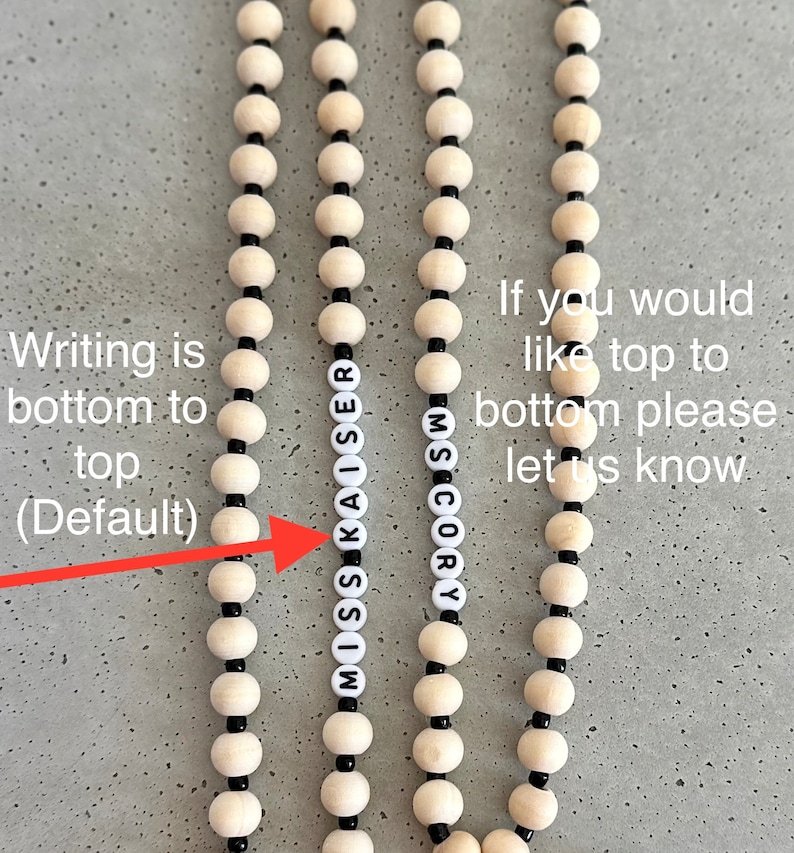 Może przedstawiać: Zbliżenie na dwa naszyjniki z drewnianych koralik&oacute;w z czarnymi koralikami. Naszyjniki tworzą napisy "MISS KAISER" i "SCORY". Tekst "Writing is bottom to top (Default)" jest napisany po lewej stronie obrazu, a tekst "If you would like top to bottom please let us know" jest napisany po prawej stronie obrazu.