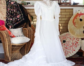 Suknia ślubna w stylu vintage z lat 70. w stylu wiktoriańskim, koronkowa, z rękawami typu juliet, długim trenem z falbanką, romantyczna suknia ślubna w stylu boho