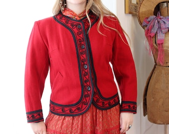 Chaqueta folklórica guatemalteca vintage de Sololá, de lana color rojo intenso, ribete bordado negro y bolsillos, estilo folk bohemio.