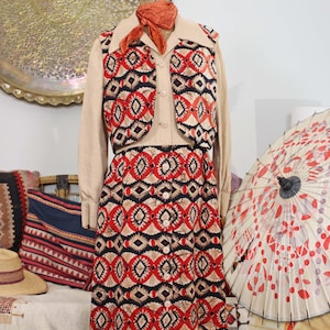 Vintage jaren 70 Bullocks Wilshire Adele Simpson overhemdjurk met knoopsluiting, vest en blouse in crème, rood en zwart met batik, folkprint, boho retrostijl uit de jaren 70.
