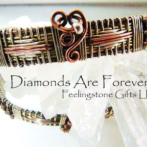 Könnte beinhalten: Ein silbernes und kupfernes Armband aus Draht mit einem Herzdesign. Das Armband ist mit verschiedenen Drahtfarben und -texturen gewebt. Der Text "Diamonds Are Forever Feelingstone Gifts LLC" ist auf dem Bild zu sehen.
