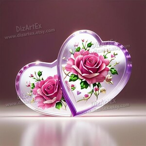 May include: Two clear glass heart-shaped ornaments with purple trim, each featuring a pink rose with green leaves and smaller pink flowers. The ornaments are on a white surface.