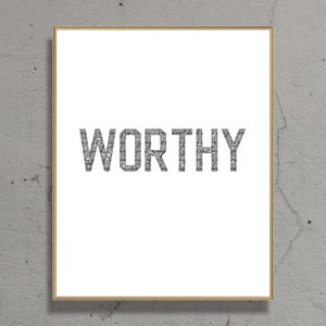 K&ouml;nnte beinhalten: Ein gerahmter Druck mit dem Wort "WORTHY" in gro&szlig;en, fetten, grauen Buchstaben auf wei&szlig;em Hintergrund.