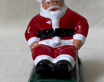 Santa Claus riding on a sled, Christmas Village holiday display, train layout, vintage toy figure reproduction