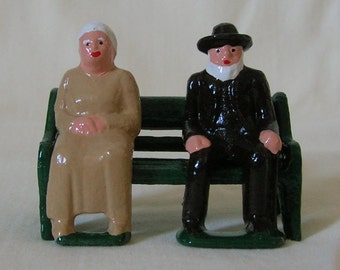 Old Couple sitting on a bench, G scale/Standard Gauge model train layout, hand-painted reproduction of vintage toy figures