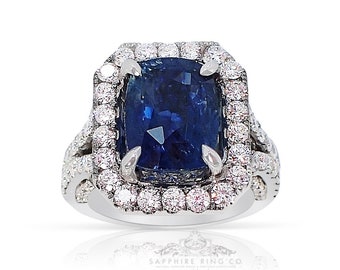 May include: A platinum engagement ring with a large, cushion-cut sapphire surrounded by a double halo of diamonds.