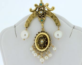 May include: A gold-toned pendant with a black and white star design, surrounded by pearls and green gemstones. The pendant is attached to a gold-toned chain with a crescent moon shape.