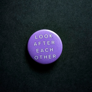 May include: Purple button with the text "LOOK AFTER EACH OTHER" in white.