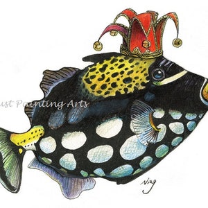 May include: A black and white spotted fish with a yellow and black head wearing a red and gold jester's hat. The fish has a blue and green tail fin and is swimming to the right.