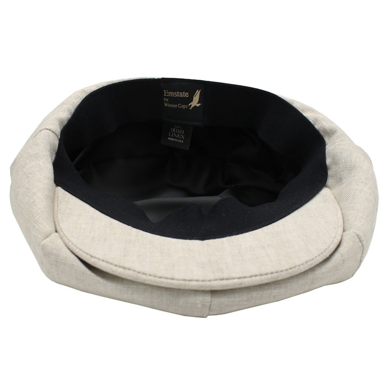 Pode incluir: O interior de um bon&eacute; de linho bege com forro preto. O r&oacute;tulo diz "Emstate by Winter Caps" e "Irish Linen Made in USA."