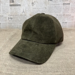 May include: A dark green suede baseball cap with a curved brim.