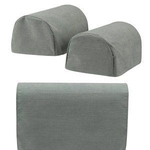 Puede incluir: Conjunto de tres fundas para reposabrazos de tela gris. Dos fundas tienen forma de semicilindros y una funda es un rectángulo largo con un borde redondeado.